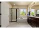 Bright bathroom featuring double sinks, a soaking tub, and a separate glass shower at 10653 E 163Rd Ct, Brighton, CO 80602