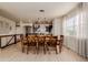 Dining room with a large wood table, modern light fixture, and view into the kitchen at 10653 E 163Rd Ct, Brighton, CO 80602