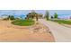 A view of the home showing mature landscaping, a long driveway and decorative rock features at 10653 E 163Rd Ct, Brighton, CO 80602