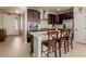 Open concept kitchen featuring stainless appliances, dark cabinetry, white countertops, and breakfast bar seating at 10653 E 163Rd Ct, Brighton, CO 80602