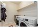 Well-lit laundry room with modern washer and dryer, and extra storage space at 10653 E 163Rd Ct, Brighton, CO 80602