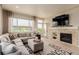 Spacious living room features a fireplace, neutral decor, backyard access and large windows at 10653 E 163Rd Ct, Brighton, CO 80602
