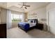 Main bedroom featuring a tray ceiling, ceiling fan, and large windows at 10653 E 163Rd Ct, Brighton, CO 80602