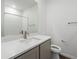 Modern bathroom with white subway tiles, quartz countertop, and gray cabinets at 6153 N Ceylon St # 201, Denver, CO 80249