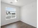 Spacious bedroom with large window, hardwood floors, and neutral walls at 6153 N Ceylon St # 201, Denver, CO 80249