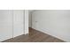 Simple bedroom with white walls, hardwood floors, and double doors at 6153 N Ceylon St # 201, Denver, CO 80249