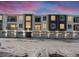 Modern two-story townhome building with attached garages and snow-covered parking lot at 6153 N Ceylon St # 201, Denver, CO 80249