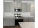 Modern kitchen with stainless steel appliances and gray cabinets at 6153 N Ceylon St # 201, Denver, CO 80249