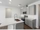 Modern kitchen with gray cabinets, quartz countertops, and stainless steel appliances at 6153 N Ceylon St # 201, Denver, CO 80249