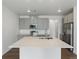 Kitchen island with white quartz countertop and stainless steel sink at 6153 N Ceylon St # 201, Denver, CO 80249
