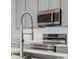 Stainless steel appliances and gray cabinets in this modern kitchen at 6153 N Ceylon St # 201, Denver, CO 80249