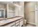 Bright bathroom featuring double sinks, a large mirror, shower and toilet at 7493 S Quail Cir # 928, Littleton, CO 80127