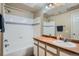 This bathroom has a shower and tub, a mirror, and a sink with a vanity at 7493 S Quail Cir # 928, Littleton, CO 80127