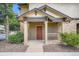 Charming covered entrance with stone accents, a red door and manicured landscaping at 7493 S Quail Cir # 928, Littleton, CO 80127