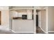 This cozy kitchen features white cabinets and a breakfast bar connecting it to the living area at 7493 S Quail Cir # 928, Littleton, CO 80127