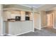 A cozy kitchen features white cabinets and a breakfast bar connecting it to the living area at 7493 S Quail Cir # 928, Littleton, CO 80127