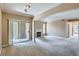 Spacious living room with fireplace, sliding glass door, and neutral carpet at 7493 S Quail Cir # 928, Littleton, CO 80127