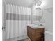 Bathroom featuring a wooden vanity with modern fixtures and a shower with a curtain at 3270 Depew St, Wheat Ridge, CO 80212