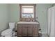 Bathroom with wooden vanity, white countertop, and decorative framed mirror at 3270 Depew St, Wheat Ridge, CO 80212