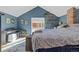 Cozy main bedroom featuring a blue accent wall, a brick chimney accent, and sliding glass doors to the outside at 3270 Depew St, Wheat Ridge, CO 80212