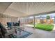 Backyard patio is covered and furnished with seating area, rug, coffee table, and a view of the lawn at 4731 S Acoma St, Englewood, CO 80110