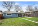 Backyard with lush green lawn, wood fence, patio with seating, and light blue siding on the house at 4731 S Acoma St, Englewood, CO 80110