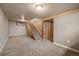 Finished basement with carpet and wooden staircase with matching wooden accents at 4731 S Acoma St, Englewood, CO 80110