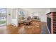 Bright living room with hardwood floors, a red brick fireplace, and an open floor plan to dining room at 4731 S Acoma St, Englewood, CO 80110