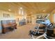 Finished basement with an exercise area, wet bar, and wooden ceiling at 13525 Woodmoor West Dr, Larkspur, CO 80118