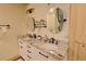 Bathroom showcasing double sinks, a granite countertop, and white plank accent wall at 13525 Woodmoor West Dr, Larkspur, CO 80118