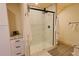 Bathroom with tiled shower, wood-look flooring, and shaker style cabinet at 13525 Woodmoor West Dr, Larkspur, CO 80118