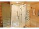 Features a glass-enclosed walk-in shower with tiled walls and floors, and a view of the wooded outdoors at 13525 Woodmoor West Dr, Larkspur, CO 80118