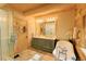 Bathroom features an antique style bathtub, a glass door shower, a double vanity and wooden walls at 13525 Woodmoor West Dr, Larkspur, CO 80118
