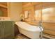Bathroom features a vintage bathtub, a window with wood blinds, wooden walls and a green painted vanity at 13525 Woodmoor West Dr, Larkspur, CO 80118
