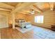 Spacious log cabin bedroom with exposed beams, hardwood floors, an area rug and a window view at 13525 Woodmoor West Dr, Larkspur, CO 80118