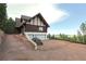 Log home featuring a circular driveway, attached garage, and expansive views of the surrounding landscape at 13525 Woodmoor West Dr, Larkspur, CO 80118