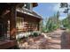 Charming log cabin featuring a stone walkway and lush landscaping leading to the entrance at 13525 Woodmoor West Dr, Larkspur, CO 80118