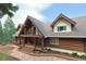 Inviting log home with stone pathway, covered porch and custom railings welcomes you to mountain living at its finest at 13525 Woodmoor West Dr, Larkspur, CO 80118