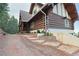 Charming log home featuring stone steps leading to the house surrounded by flower beds at 13525 Woodmoor West Dr, Larkspur, CO 80118