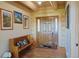 Welcoming foyer with hardwood floors, wooden bench, and rustic charm with mountain art at 13525 Woodmoor West Dr, Larkspur, CO 80118