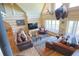 Cozy log home living room featuring high ceilings, natural light, and comfortable seating, perfect for relaxation at 13525 Woodmoor West Dr, Larkspur, CO 80118