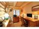 Wooden-walled office with a computer desk, printer, and rustic decor create a cozy workspace at 13525 Woodmoor West Dr, Larkspur, CO 80118