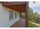 Covered patio offering a shady retreat with views of the lush greenery and mature trees at 13525 Woodmoor West Dr, Larkspur, CO 80118