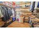 A wooden walk-in closet with shelves, drawers, and hangers for clothes, shoes, and other items at 13525 Woodmoor West Dr, Larkspur, CO 80118
