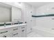Bright bathroom featuring a double vanity, modern fixtures, and subway tiled shower and floors at 7649 E Amherst Ave, Denver, CO 80231