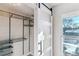 Bedroom closet with custom metal shelving and storage, and a sliding barn door at 7649 E Amherst Ave, Denver, CO 80231