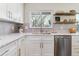 Bright kitchen with white cabinets, quartz countertops, stainless steel appliances, and modern fixtures at 7649 E Amherst Ave, Denver, CO 80231