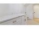 Laundry area with white cabinets, white countertop, and decorative flooring at 7649 E Amherst Ave, Denver, CO 80231