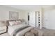 Well-staged bedroom with soft lighting, a plush bed, and an organized closet at 17325 E Rice Cir # F, Aurora, CO 80015