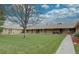 Well-maintained front lawn with mature tree providing shade for multi-unit dwelling at 3376 Jasmine St, Denver, CO 80207